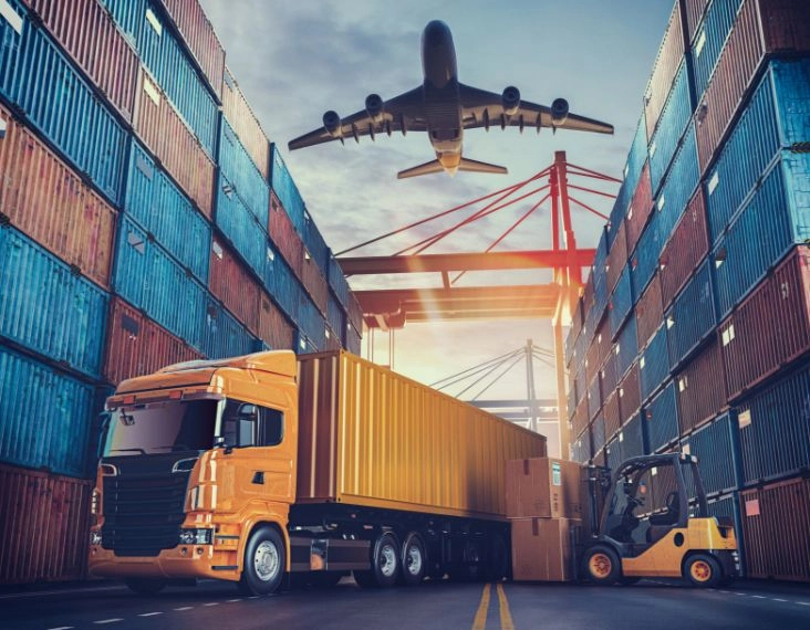 Verschiedene Transportfahrzeuge stehen in Hafen vor Seecontainern