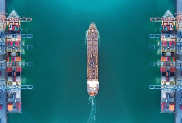 Schiff fährt durch Hafen mit Kränen