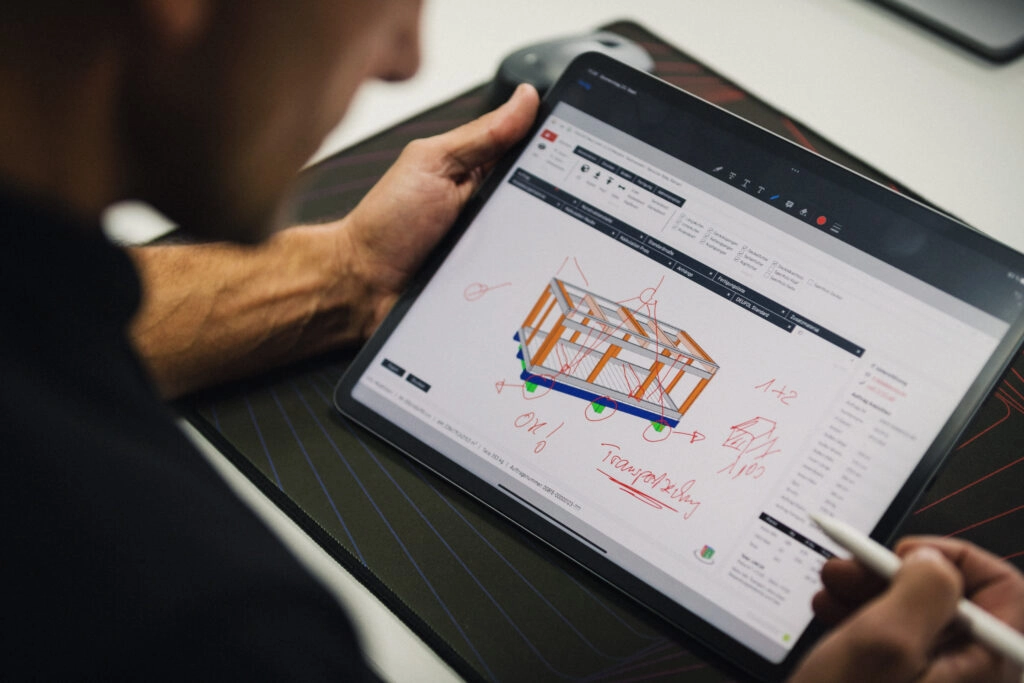 Ein Mann entwirft auf einem Tablet eine Holzverpackung für den Transport.