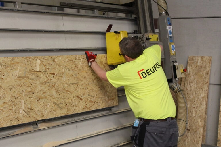 Eine Seefrachtkiste und Seefrachtverpackung wird von einem DEUFOL-Mitarbeiter mit einer Machine gefertigt.
