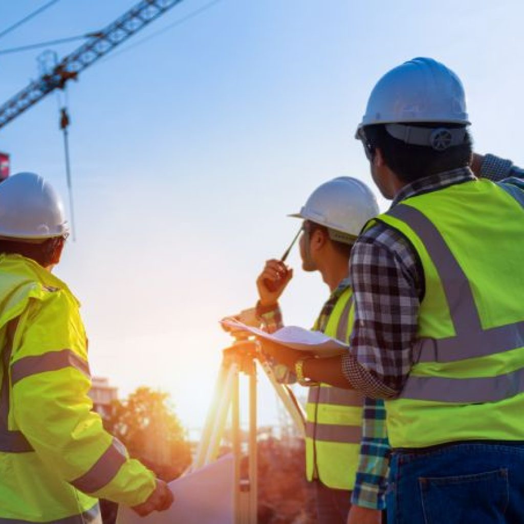 Baustellenlogistik-Arbeiter mit Warnwesten prüfen Projektstatus